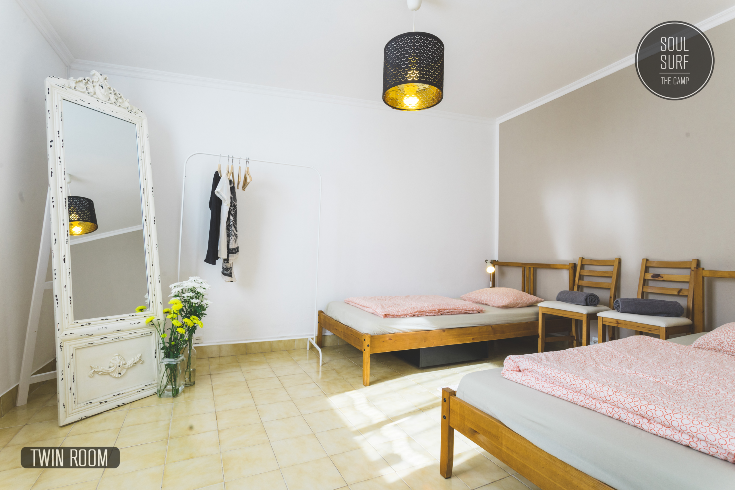 Schlafzimmer mit zwei Betten und einem großen Spiegel